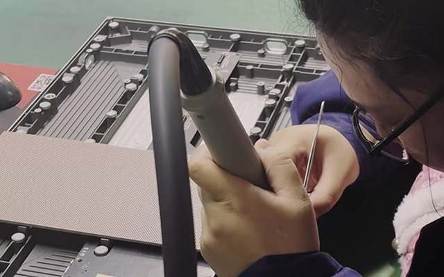 A technician inspects tiny pixels