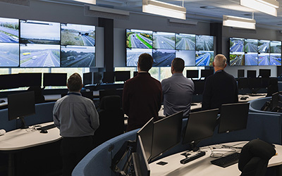 four control room operators view images of road networks