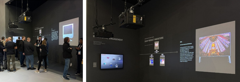 two ceiling-mounted projectors project images onto a black wall