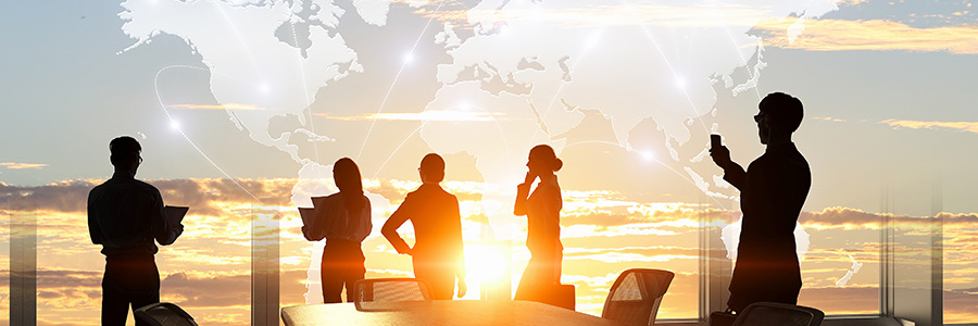 Business people are silhouetted against a setting sun